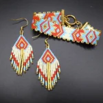 Bracelet et boucles d'oreille coordonnés en perles miyuki delica 11/0 tissées à la main. Les motifs sont d'inspiration azteque. Les couleurs dominantes sont le bleu, le blanc et le rouge. Ces bijoux sont des pièces uniques faites main par Cecile-Jeanne pour la marque Oyuni.