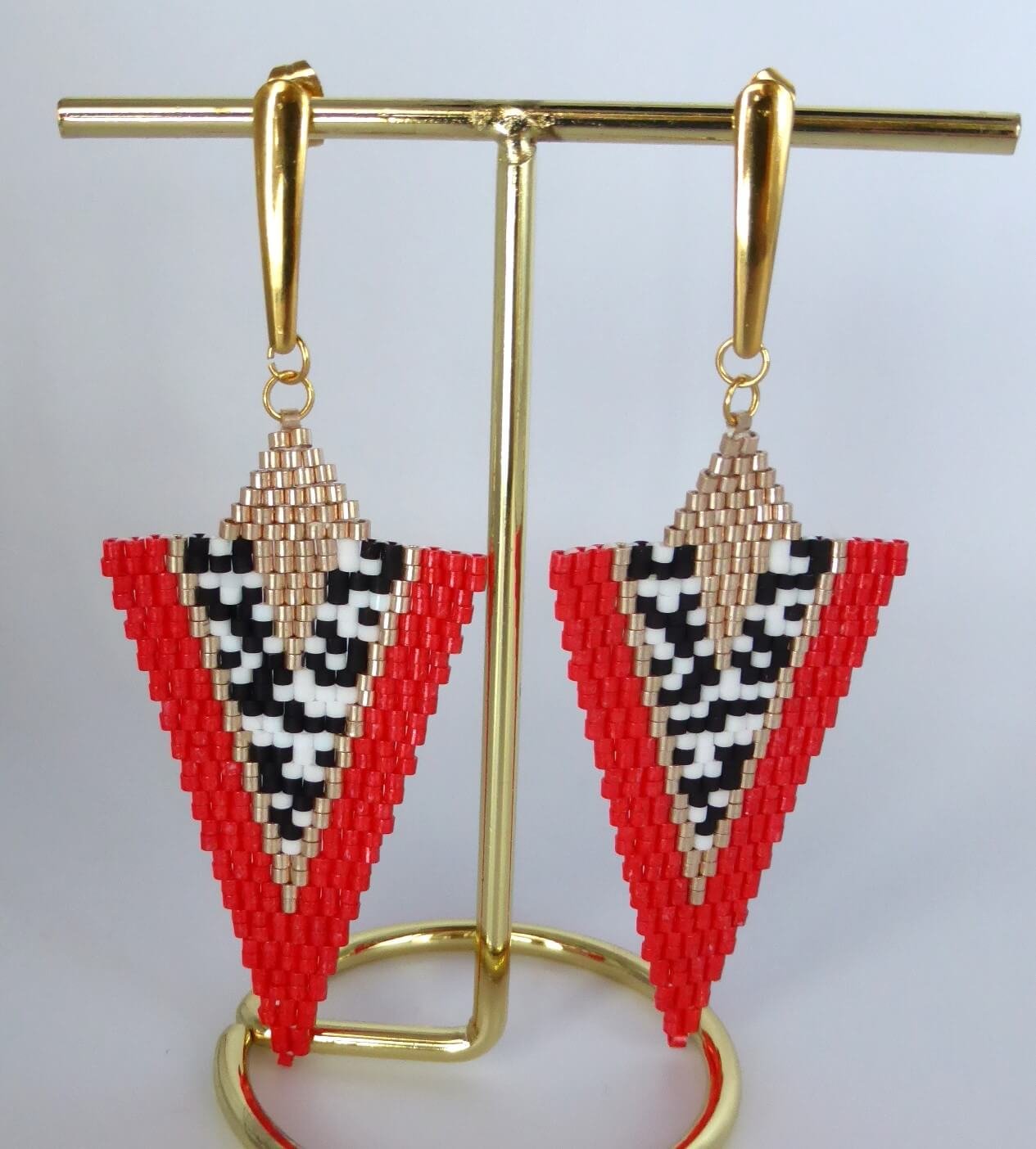 Boucles d'oreilles Rangi en perles miyuki tissées à la main. Couleur et motif d'inspiration afro-bohème. Accroche de type clou en acier inoxydable doré. Modèle rouge