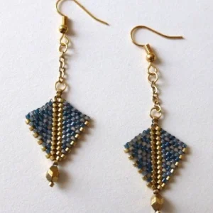 Boucles d'oreilles Arrowa en perles miyuki tissées à la main. Couleurs gris-bleu et dorée. Crochet en acier inoxydable couleur charbon. Modèle gris-bleu et doré. Vue à plat.