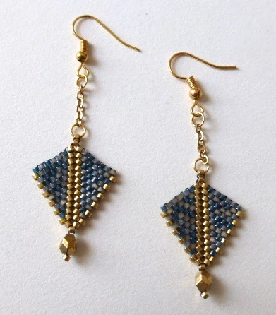 Boucles d'oreilles Arrowa en perles miyuki tissées à la main. Couleurs gris-bleu et dorée. Crochet en acier inoxydable couleur charbon. Modèle gris-bleu et doré. Vue à plat.