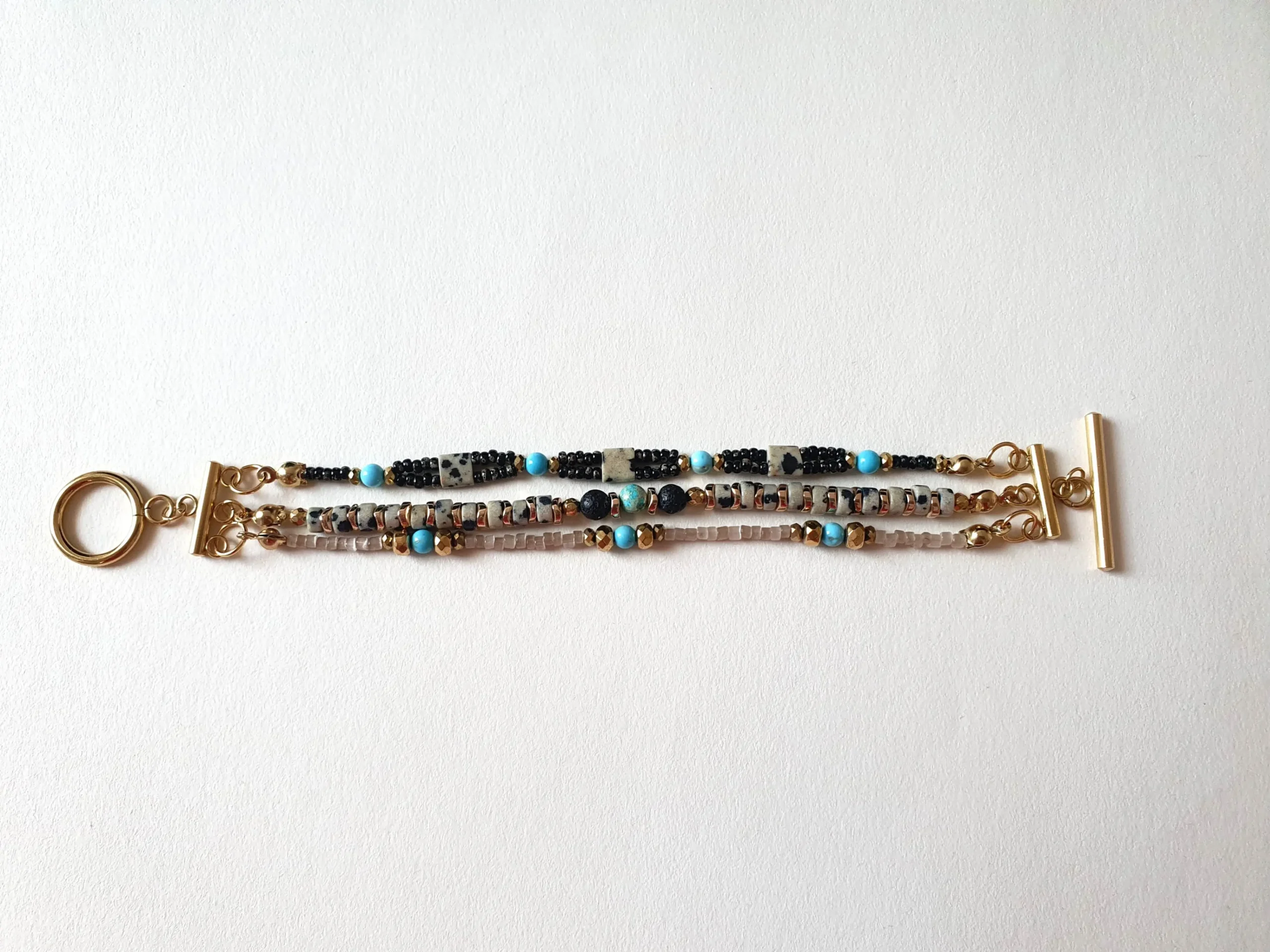 Bracelet triple rang en jaspe dalmatien et turquoise. Vue à plat.