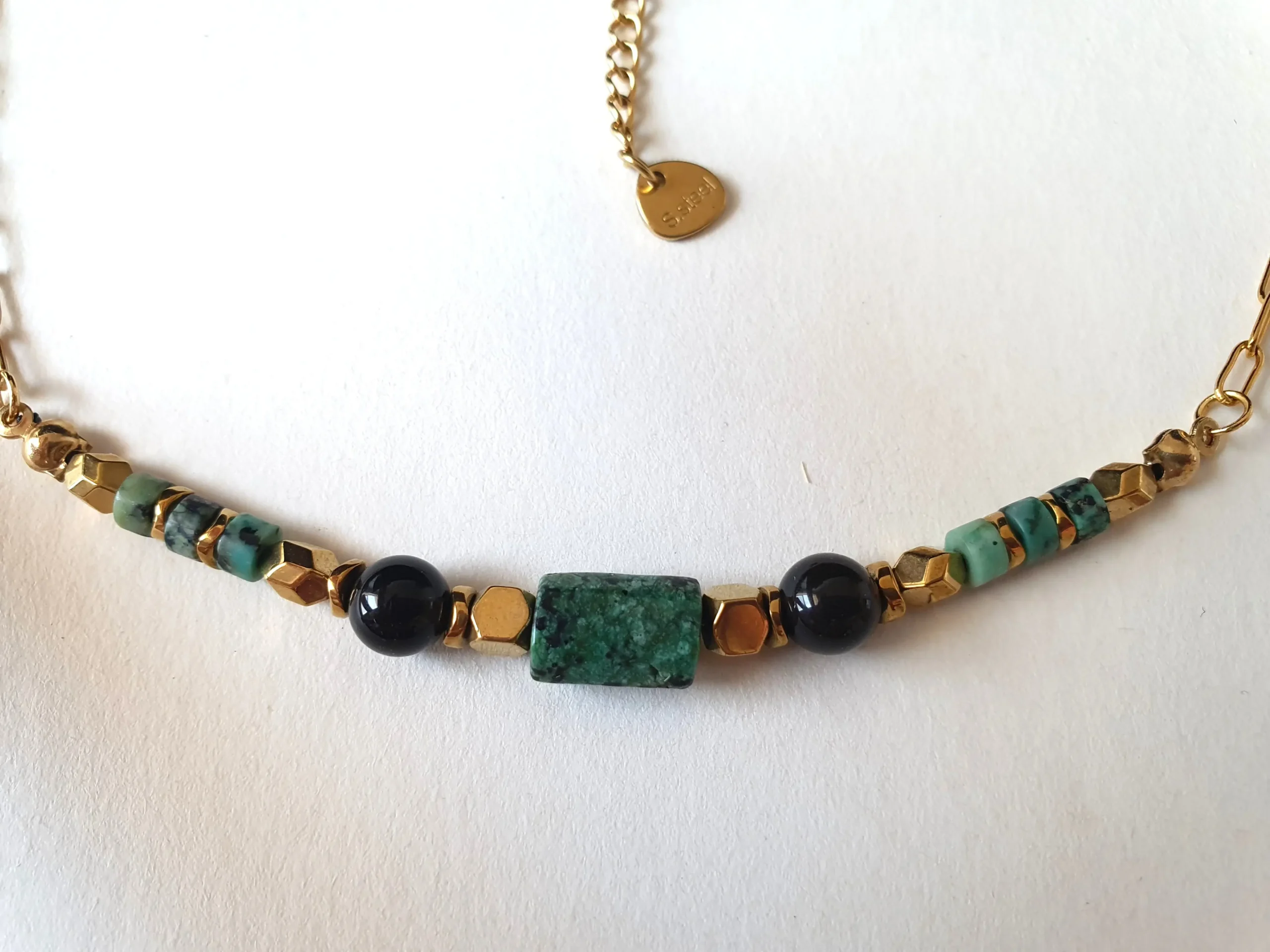 Collier ras de cou Arusha à base de turquoise africaine et obsidienne monté sur chaine en acier inoxydable doré. Zoom.