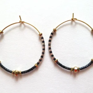 Boucles d'oreilles créoles en perles noires picasso. Vue à plat.