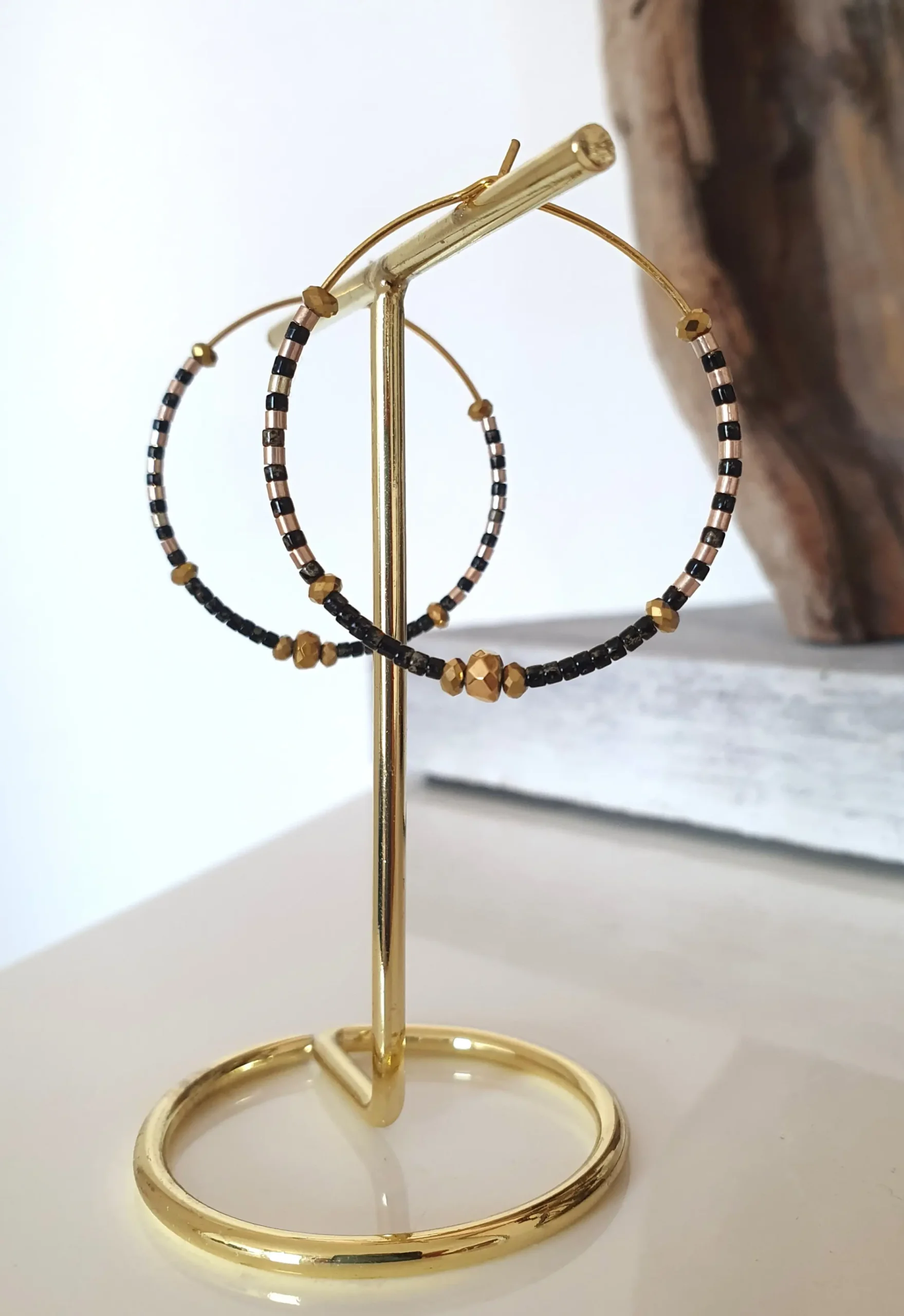 Boucles d'oreilles créoles en perles noires picasso. Vue sur portant.