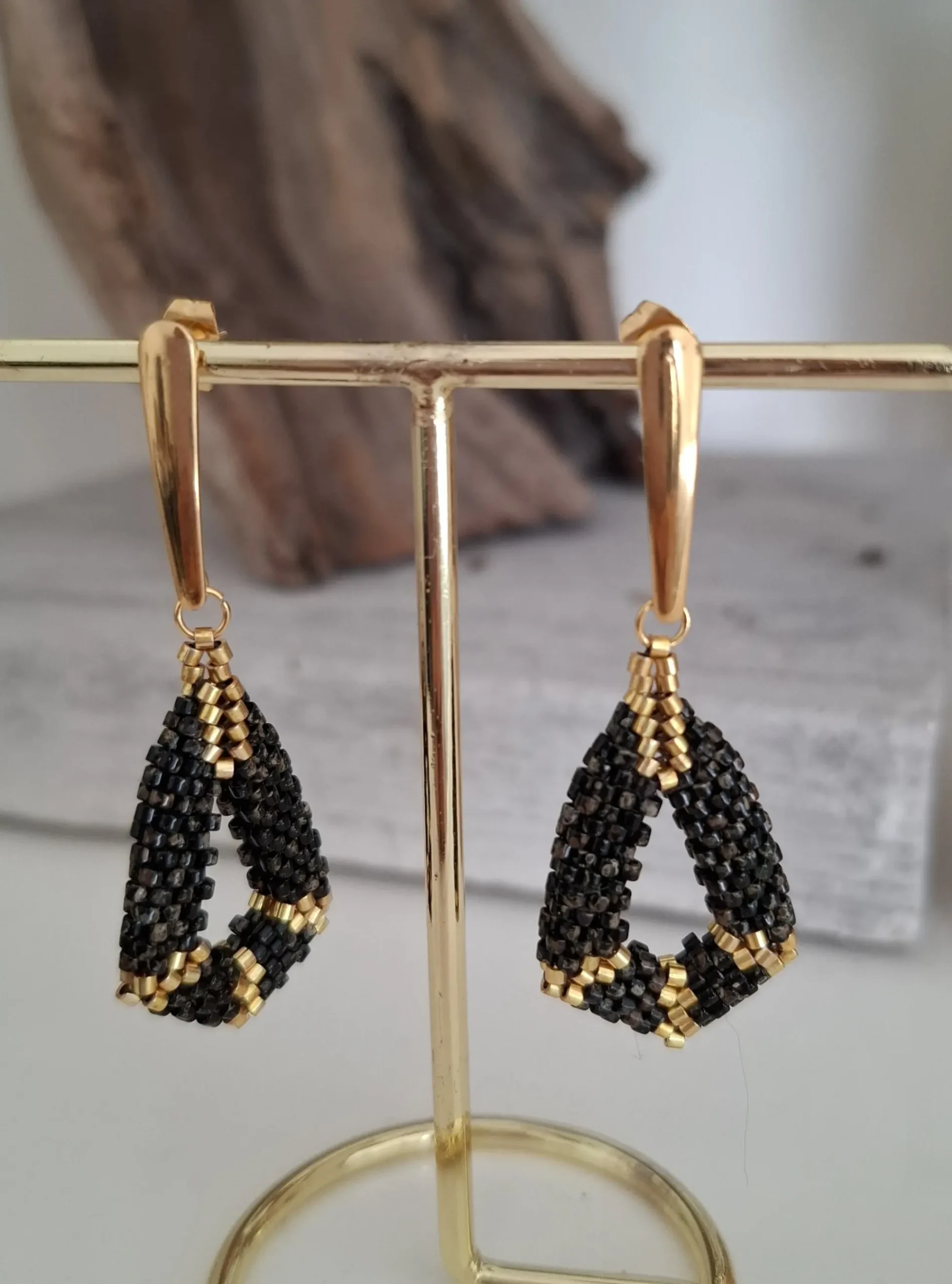 boucles d'oreilles pendantes en perles tissées noir picasso et doré. collection kimi. Vue sur portant.